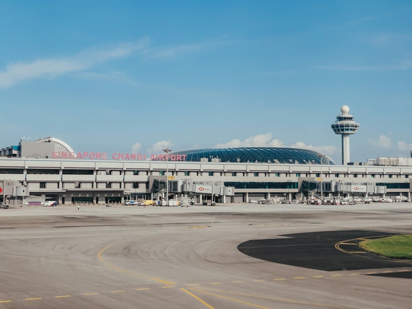 Moderno terminal aeroportuale e torre di controllo sotto un cielo blu.